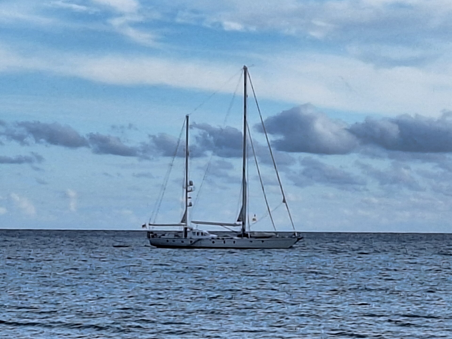 A two-masted sailing yacht on calm water off the Mallorcan coast